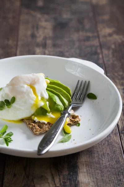 Knapperig brood met avocado en gepocheerd ei — Stockfoto