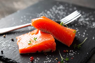 Siyah tabakta füme somon parçaları.