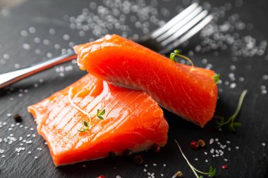 Siyah tabakta füme somon parçaları.