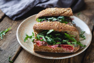 Tam tahıllı sandviç, salam ve roka.