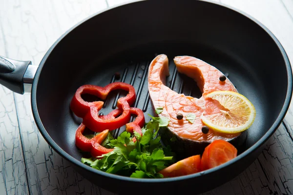 Fresh salmon steak in a pan grilled with vegetables — Stock Photo, Image