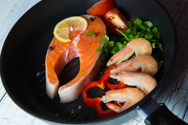 Fresh salmon steak in a pan grilled shrimp and vegetables — Stock Photo, Image