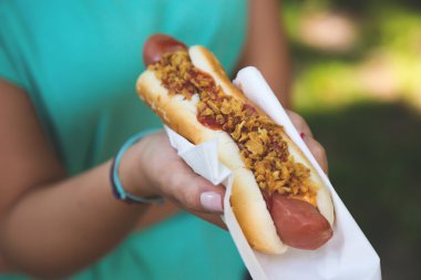 Hot dog in the hands of women, street food