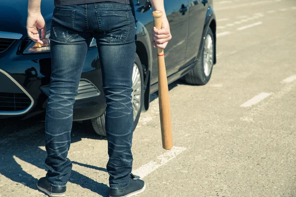 Hombre con bate de béisbol en la carretera antes del coche —  Fotos de Stock