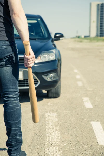 Hombre con bate de béisbol en la carretera antes del coche — Foto de Stock