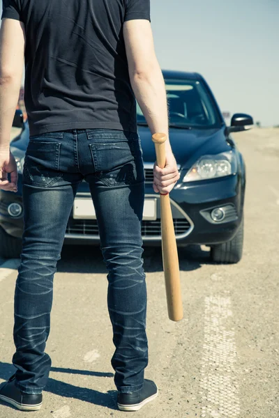 Hombre con bate de béisbol en la carretera antes del coche — Foto de Stock