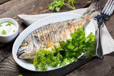 Yeşillikleri ile ızgara bütün balık