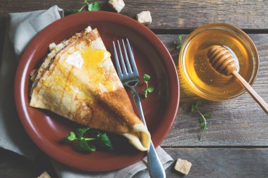 Ahşap bir masa üzerinde ballı krep