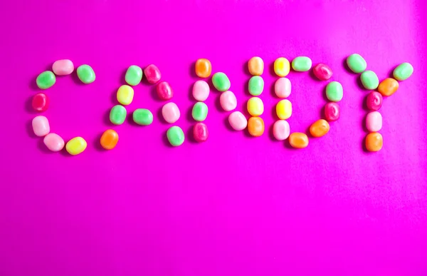 Слово "конфеты" на розовом фоне — стоковое фото