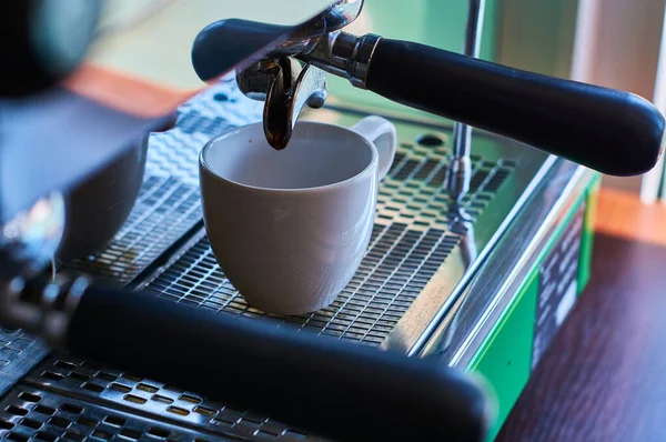 プロのコーヒーマシン上の白いセラミックカップでコーヒーを作るプロセス — ストック写真