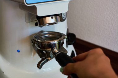 Kahve makinesinde espresso yapmak için tahıl öğütme işlemi. Kahve dükkanında barmenlik işi..