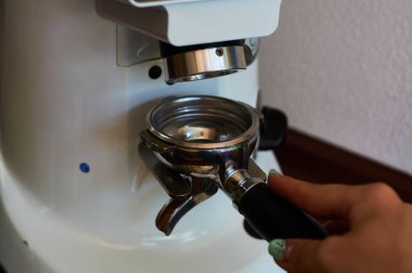 Kahve makinesinde espresso yapmak için tahıl öğütme işlemi. Kahve dükkanında barmenlik işi..