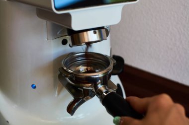 Kahve makinesinde espresso yapmak için tahıl öğütme işlemi. Kahve dükkanında barmenlik işi..