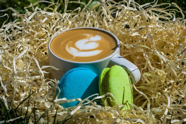 Cappuccino Białym Ceramicznym Kubku Latte Art Niebieskimi Zielonymi Makaronikami Dekoracyjne — Zdjęcie stockowe