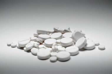 Pile of white tablets, shot on white with shadows and graded illumination clipart