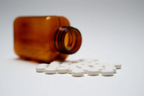 Comprimidos blancos genéricos y frasco de medicamento marrón Imagen de archivo