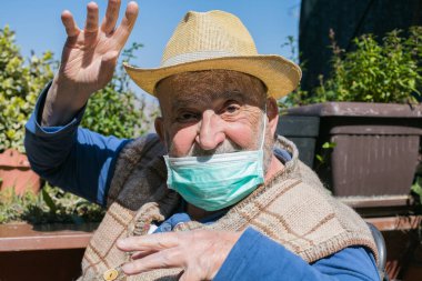 Yüzü maskeli yaşlı bir adam alay ediyor ve alay ediyor.