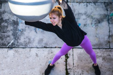 sağlıklı genç bir kadın dışarıda pilates yapıyor.