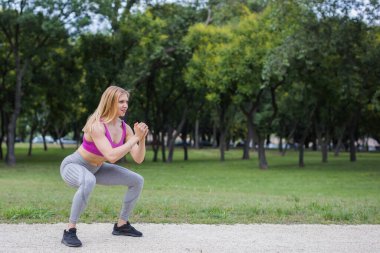Açık havada çömelmeye hazır genç bir kadın.