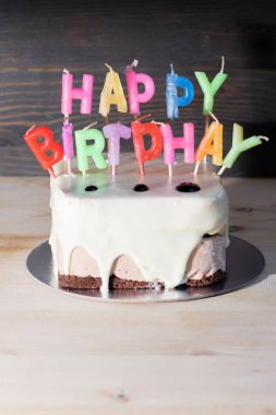 Tahta masada mumlar olan doğum günü pastası.