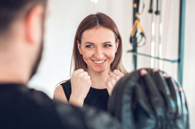 Kişisel antrenörle çalışan genç bir kadın.