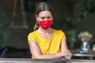 Koronavirüs salgını sırasında maske takan genç bir kadın depresyonda.