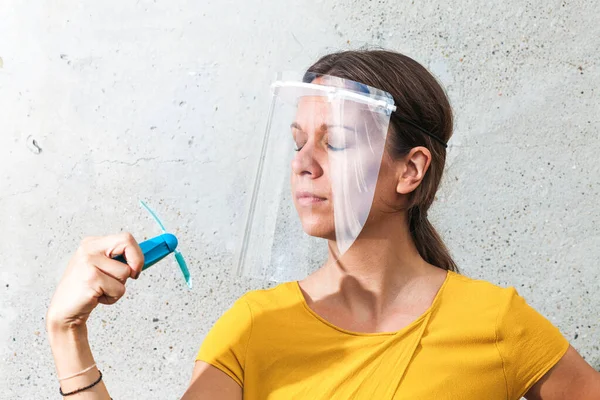 Wanita Muda Pendinginan Dengan Tangan Memegang Ventilator Sambil Mengenakan Pelindung — Stok Foto