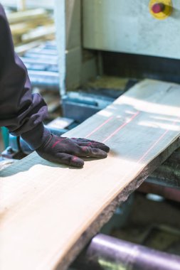 İşçi kalası lazer kesme makinesine itiyor.