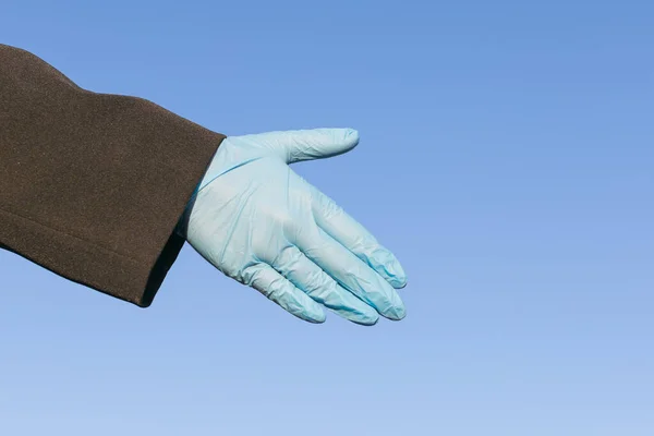 gloved hand reaching out for handshake