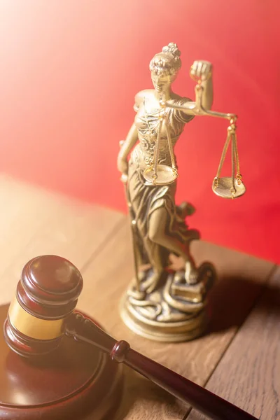 lady justice and judge gavel in front on red background