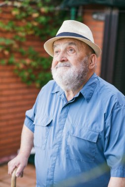 Yaşlı adam yürüyor ve hava durumunu kontrol ediyor.