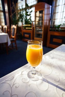 Restorandaki masada bir bardak portakal suyu.