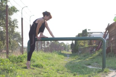 Genç bir kadın direğe tırmanmaya çalışıyor.