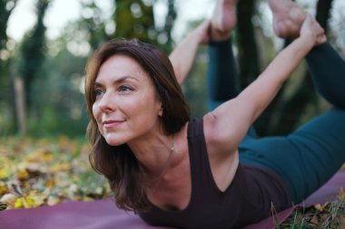 Yoga pozu veren genç bir kadın.