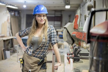 Bir atölyede çalışan genç bir kadının portresi.