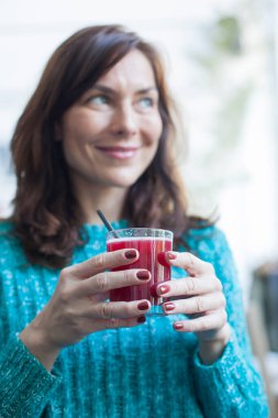 Güzel kadın meyve suyu içiyor.