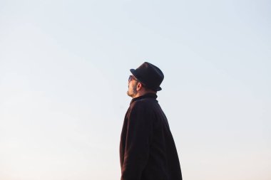 Şapkalı adam gökyüzüne bakıyor.