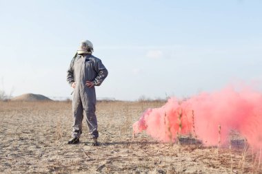 Düşen pilot, çöl bölgesinde sis bombasıyla kurtarma sinyali veriyor.