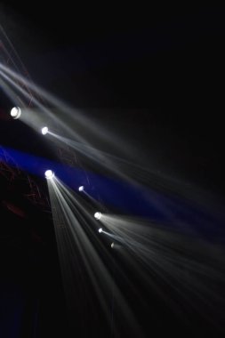 Sahnede bir sürü spot ışığı parlıyor.