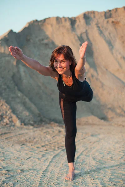 young woman doing warrior 3 yoga pose