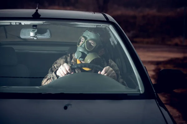 ガソリンマスクで車を運転する兵士は — ストック写真