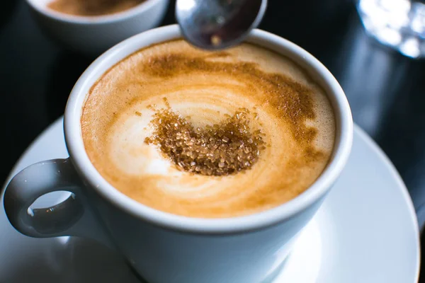 Menuangkan Gula Coklat Dalam Cappuccino — Stok Foto