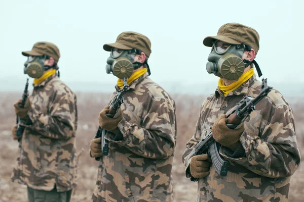 soldiers with gas mask and automatic guns standing ready