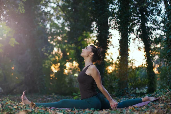 Maymun yoga pozu veren genç bir kadın.