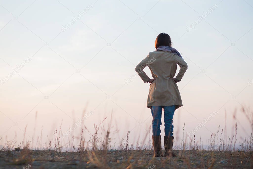 young woman standing alone on barren land