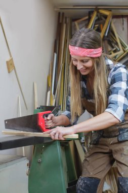 Genç bir kadın tahta kesiyor.