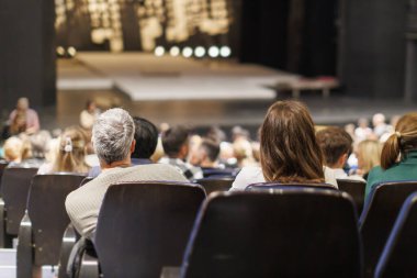 İzleyiciler bir akşam şovu sırasında tiyatroda gösteri izliyorlar.