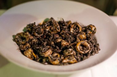 Geceleri yerel bir restoranda servis edilen yumuşakça ve siyah fasulyeli lezzetli deniz ürünleri.