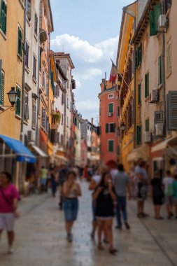 Hırvatistan 'ın sevimli Rovinj kasabasında, güneşli bir öğleden sonra, canlı binalar ve yerel dükkanlarla dolu hareketli bir cadde