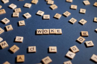 Kiremitler mavi bir arkaplanda uyanan kelimeyi hecelemek için yaratıcı bir şekilde düzenlendi